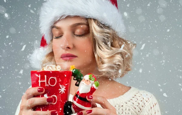 Woman in santa's hat is drinking coffee. — Stock Photo, Image