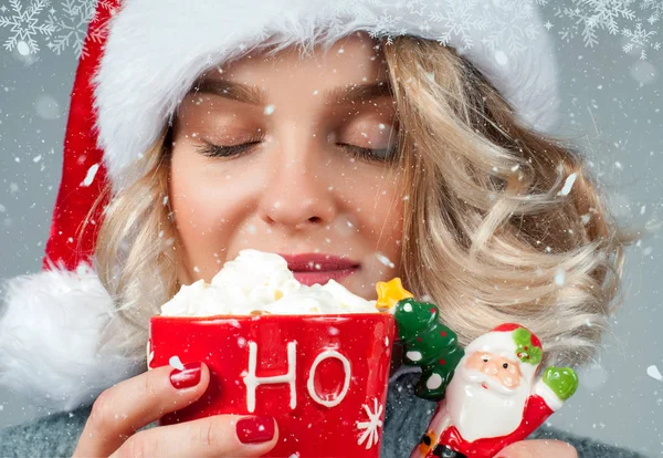 Woman in santa's hat is drinking coffee. — Stock Photo, Image