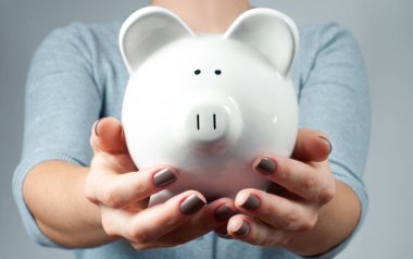Savings concept. Woman holding piggy bank  clipart