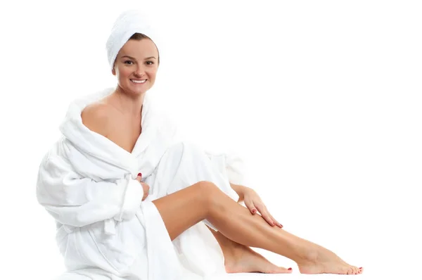 Menina bonita em roupão de banho está tocando suas pernas. Conceito de depilação e cuidados com o corpo — Fotografia de Stock