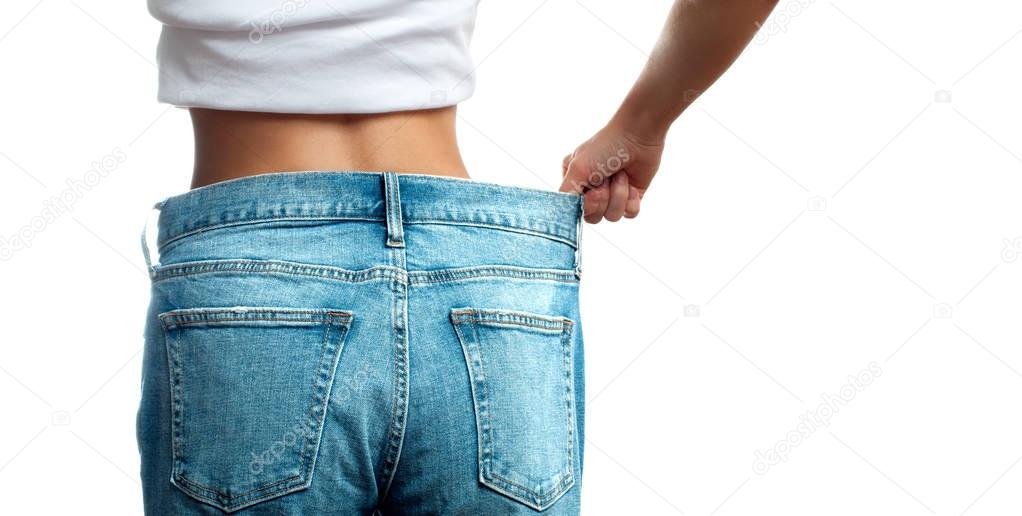 Woman in oversize jeans after weight loss, diet concept.