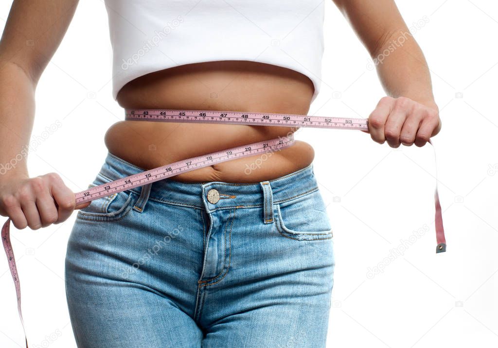 Overweight woman with tape measure around waist. 
