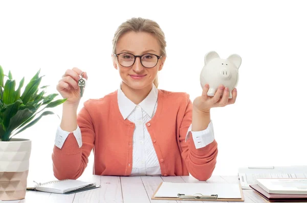 Business woman or real estate agent holding keys and piggy bank — Stock Photo, Image