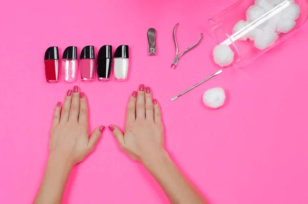 Salón de uñas. Hermosas manos femeninas con esmalte de uñas rosa —  Fotos de Stock