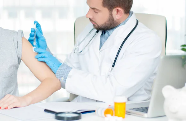 Vacinação. Tiro de gripe. Médico que injeta vacina contra a gripe no braço do doente — Fotografia de Stock