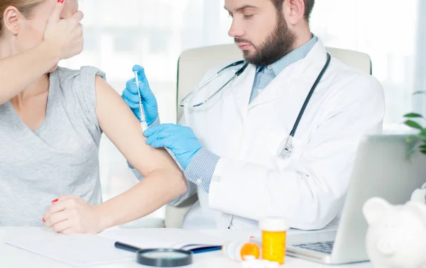Vacunación. Una vacuna antigripal. Médico inyectando la vacuna contra la gripe en el brazo del paciente —  Fotos de Stock