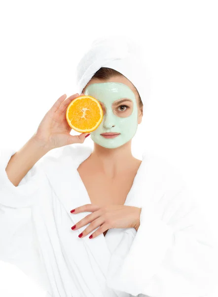 Beautiful woman is getting facial clay mask. Beauty, cosmetics, body care and spa concept — Stock Photo, Image