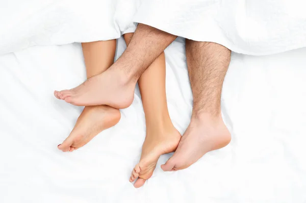 Close up of the feet of a couple on the bed. — Stock Photo, Image