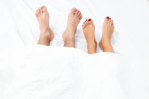 Close up of the feet of a couple on the bed. — Stock Photo, Image