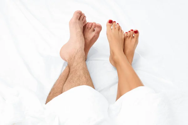 Close up of the feet of a couple on the bed. — Stock Photo, Image