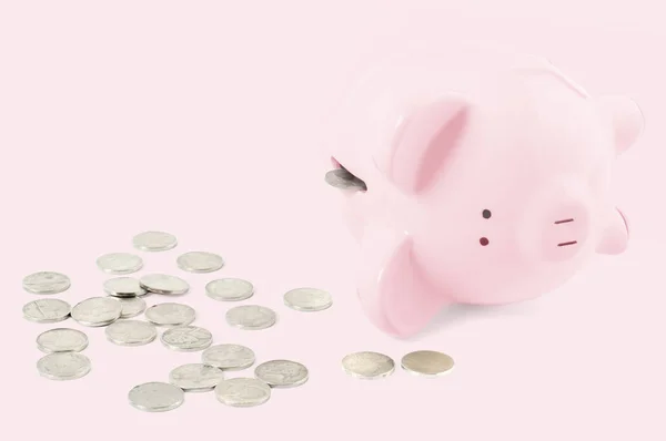 空存钱罐和硬币在柔和的粉红色背景 — 图库照片