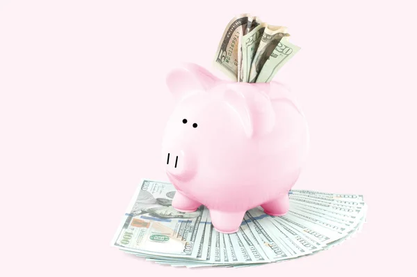 在粉彩粉红色背景的小猪银行和美元钞票 — 图库照片