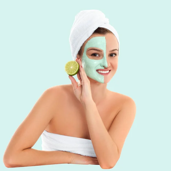 Beautiful woman with clay mask on pastel green background. Beauty and spa — Stock Photo, Image