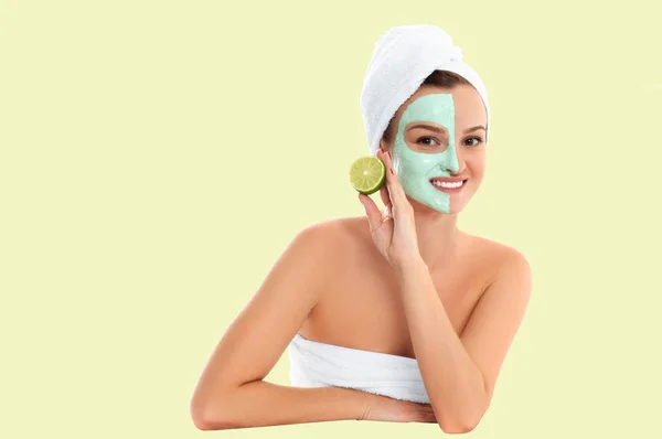 Beautiful woman with clay mask on pastel yellow background. Beauty and spa — Stock Photo, Image