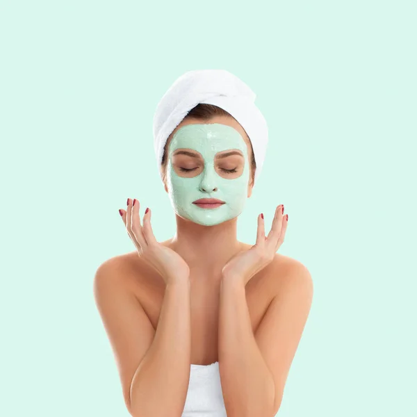 Žena je stále obličeje jílová maska na pastelově zeleném pozadí. Krása a wellness — Stock fotografie