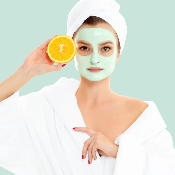 Vacker kvinna med lermask på Pastell grön bakgrund. Skönhet och spa — Stockfoto