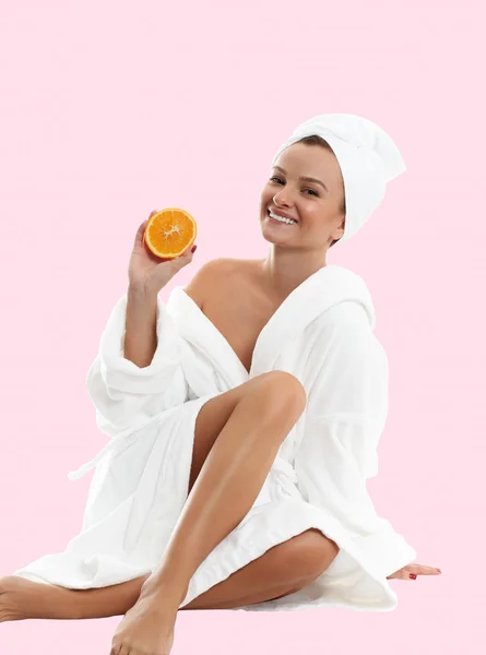 Wanita cantik memakai mantel mandi dengan latar belakang merah muda. Konsep kecantikan dan spa — Stok Foto