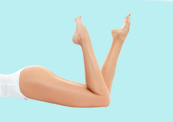 Pernas da mulher com pele lisa após depilação em fundo pastel . — Fotografia de Stock