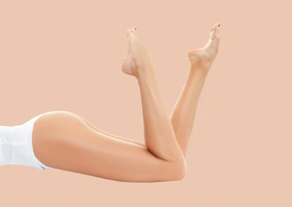 Frauenbeine mit glatter Haut nach Enthaarung auf pastellfarbenem Hintergrund. — Stockfoto