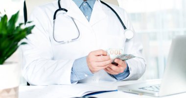 Para sayma doktor. Doktor holding dolar