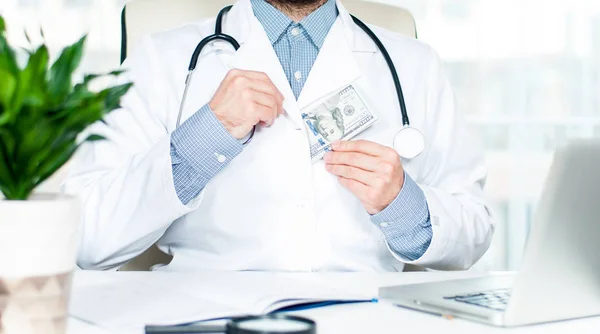 Doctor ocultando billete de cien dólares — Foto de Stock