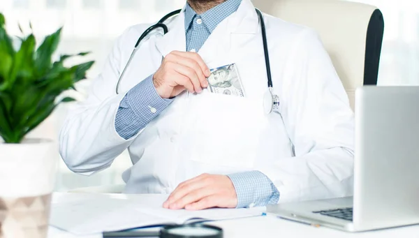 Doctor poniendo dinero en su bolsillo — Foto de Stock
