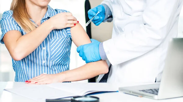 Vacunación. Una vacuna antigripal. Médico inyectando la vacuna contra la gripe en el brazo del paciente — Foto de Stock