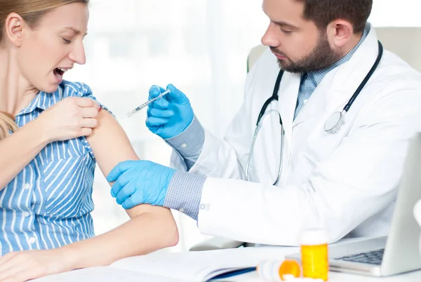 Vacunación. Una vacuna antigripal. Médico inyectando la vacuna contra la gripe en el brazo del paciente —  Fotos de Stock