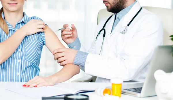 Vacunación. Una vacuna antigripal. Médico inyectando la vacuna contra la gripe en el brazo del paciente — Foto de Stock