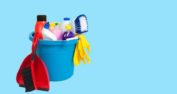 Cleaning supplies in blue bucket on pastel blue background — Stock Photo, Image