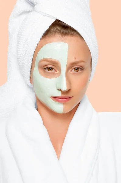 Centrum Spa. Stosowanie maski gliny na twarz kobiety. Pastelowe tło — Zdjęcie stockowe
