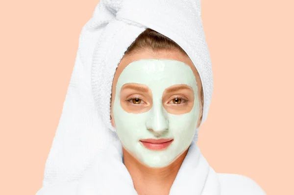 Spa Kecantikan. Wanita menerapkan masker tanah liat di wajah. Latar belakang pastel — Stok Foto