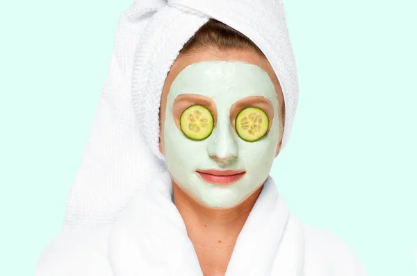 Cantik. Spa. Wanita dengan masker tanah liat wajah dan mentimun pada mata — Stok Foto