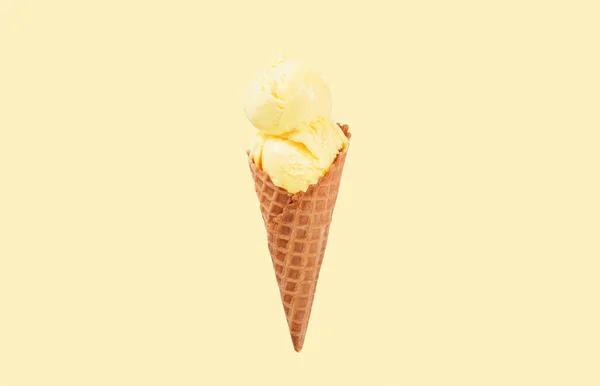 Конус ванильного мороженого на желтом выцветшем пастельном фоне . — стоковое фото