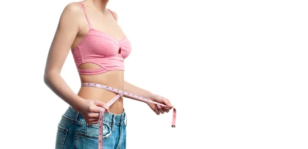 Mulher está medindo a cintura após a perda de peso no fundo branco — Fotografia de Stock