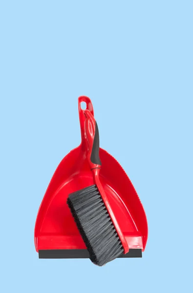 Dustpan rouge avec pinceau sur fond bleu pastel — Photo