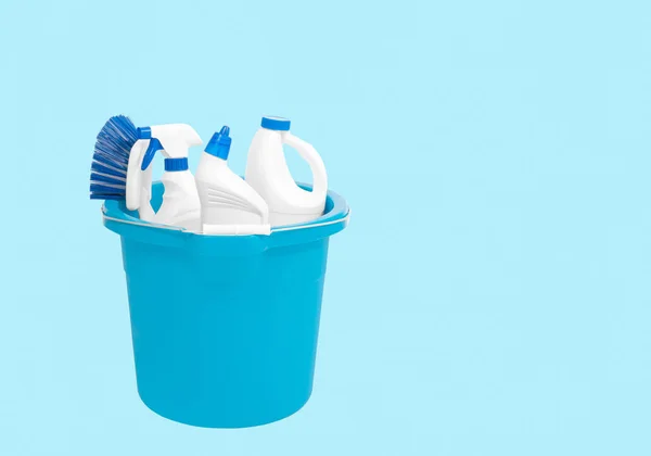 Cleaning supplies in blue bucket on pastel blue background — Stock Photo, Image