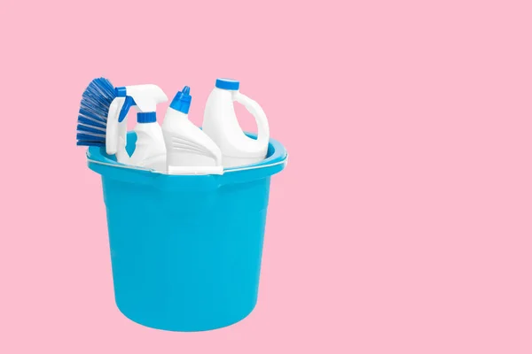 Cleaning supplies in blue bucket on pastel pink background — Stock Photo, Image