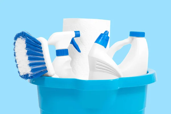 Cleaning supplies in blue bucket on pastel blue background — Stock Photo, Image