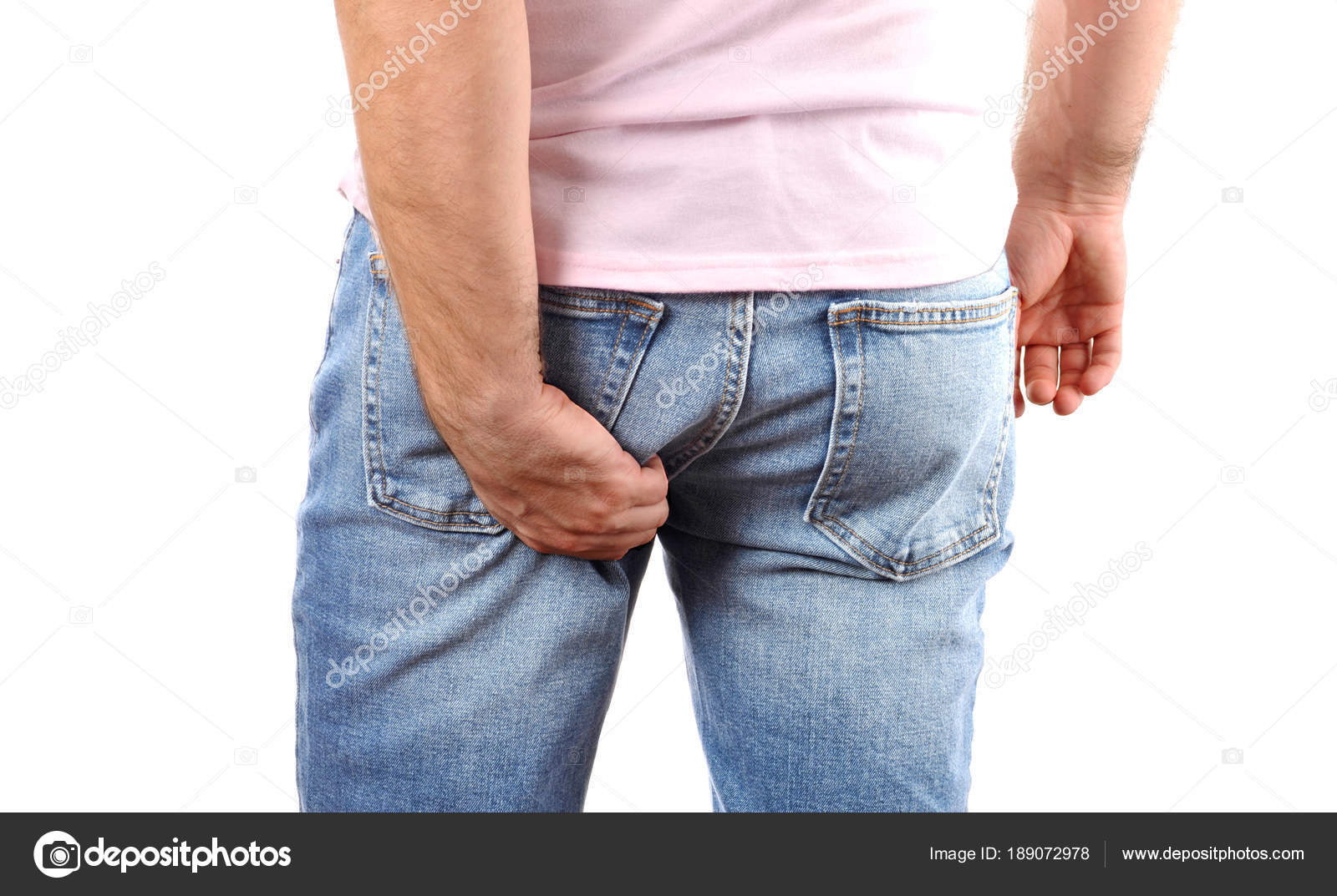 Man in jeans scratching hand his itchy bottom Stock Photo by ©flisakd