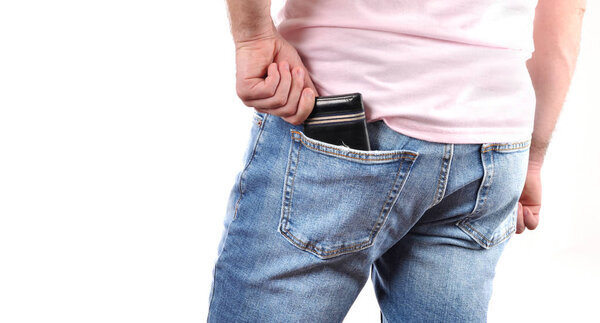 Man put wallet in a jeans pocket. 