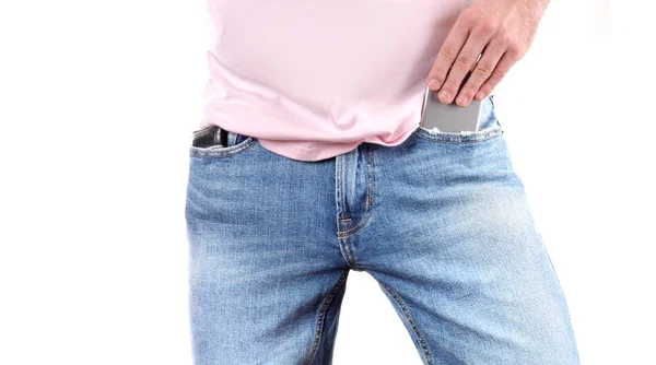 Człowiek, umieścić telefon w kieszeni jeansów. — Zdjęcie stockowe