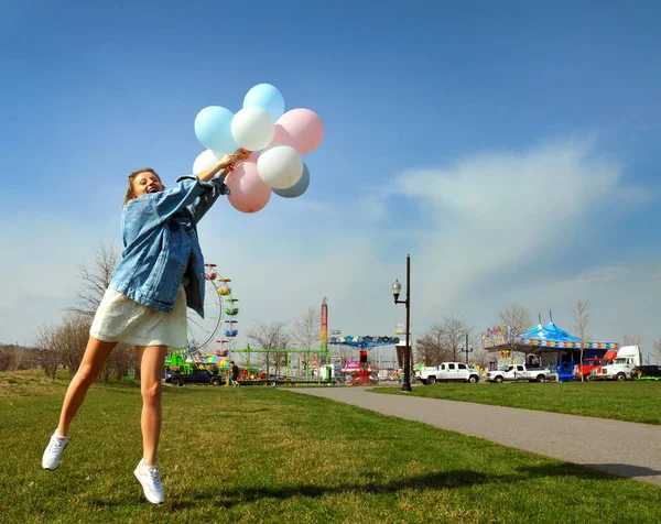 Frumoasă femeie tânără cu baloane în parcul de distracții — Fotografie, imagine de stoc