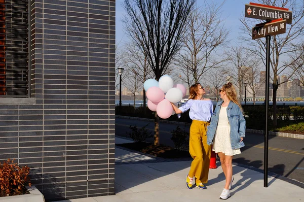 Chicas urbanas de moda con atuendo de moda con globos caminando en la calle de la ciudad de Nueva York . — Foto de Stock