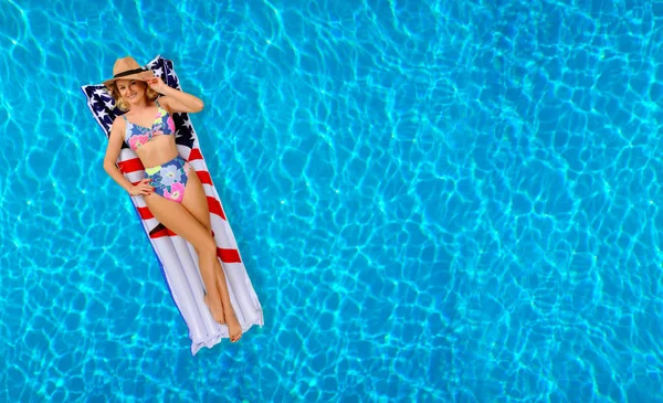 Mulher de biquíni no colchão inflável na piscina . — Fotografia de Stock