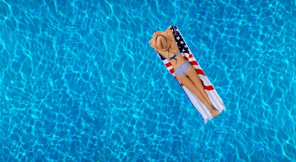 Kobieta w bikini na nadmuchiwany materac w basenie. — Zdjęcie stockowe