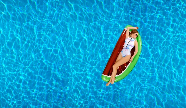 Woman in bikini on the inflatable mattress in the swimming pool. — Stock Photo, Image