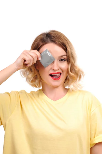 Hermosa chica cubriendo un ojo con un condón — Foto de Stock