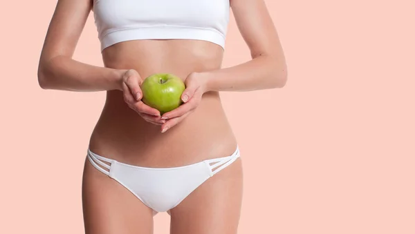 Dieet. Mooie slanke vrouw met perfect sportief lichaam houden van apple. — Stockfoto