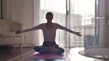 Sağlıklı bir kadın sabah evde lotus pozu vererek yoga egzersizleri yapıyor.
